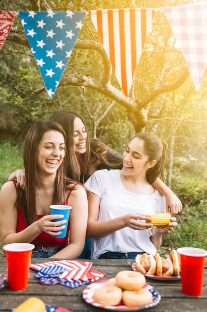 Foto gratuita chicas riendo a la mesa en el parque