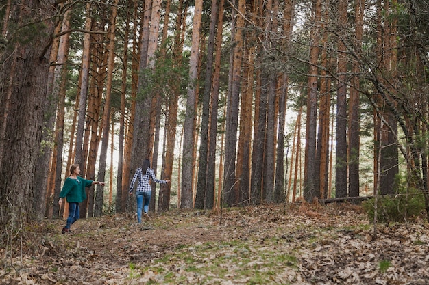 Chicas rodeadas de árboles en el bosque