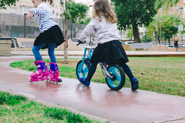 Chicas sin rostro con bicicleta y patines