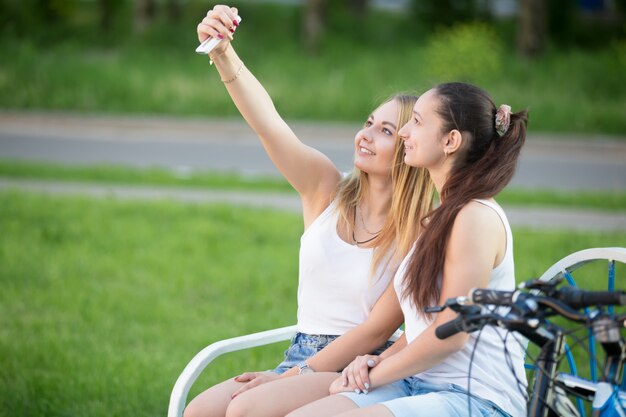 Chicas sentadas en el banco de un parque