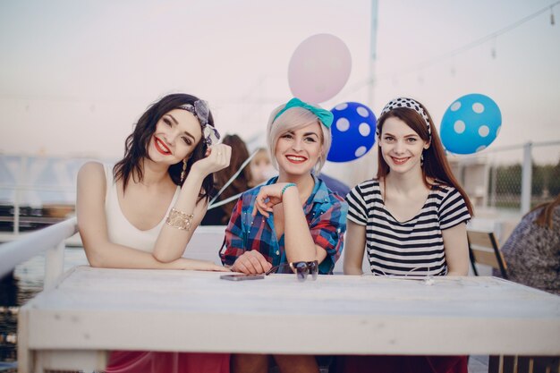 Chicas sentadas en una mesa sonriendo