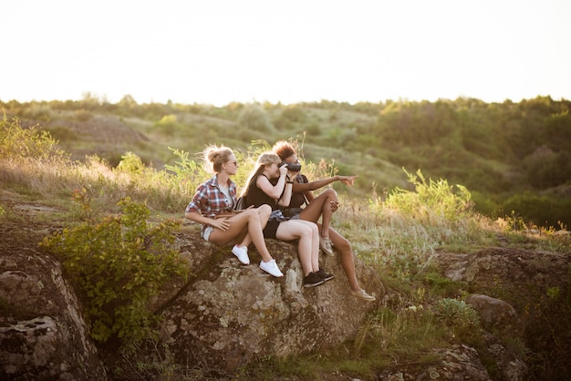 Chicas sonriendo, sentados en roca, disfrutando de la vista en el cañón