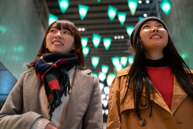 Chicas sonrientes caminando juntas tiro medio