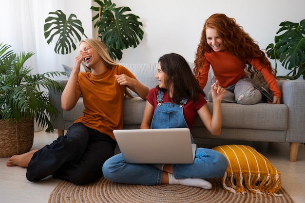 Foto gratuita chicas sonrientes de tiro completo con laptop