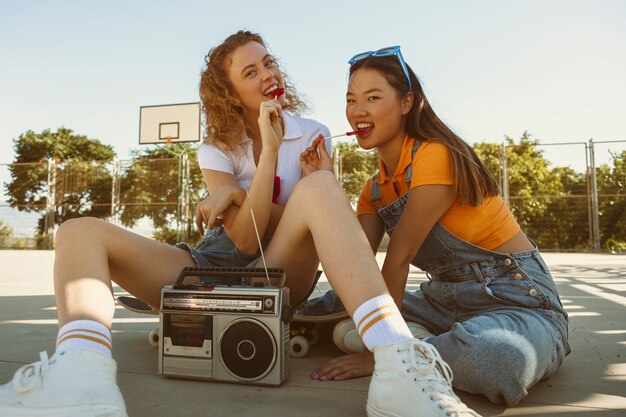 Chicas sonrientes de tiro completo con piruletas