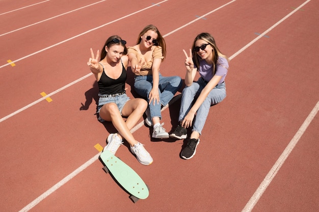 Chicas sonrientes de tiro completo sentados en el campo