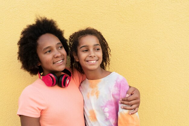 Chicas sonrientes de tiro medio abrazándose