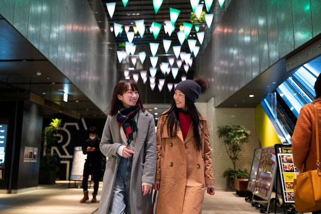 Chicas sonrientes de tiro medio caminando juntas