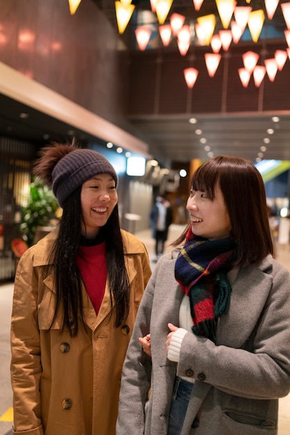 Chicas sonrientes de tiro medio en el centro comercial