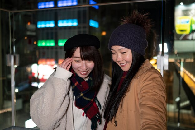 Chicas sonrientes de tiro medio en la ciudad