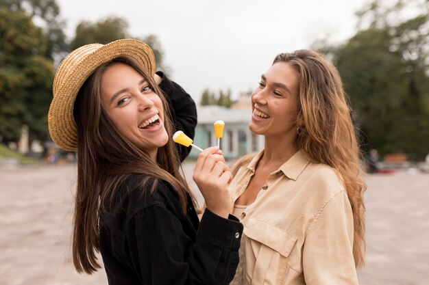 Chicas sonrientes de tiro medio con dulces