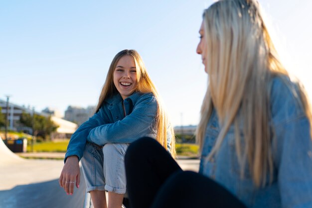 Chicas sonrientes de tiro medio en el parque de patinaje