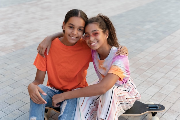 Chicas sonrientes de tiro medio en patineta