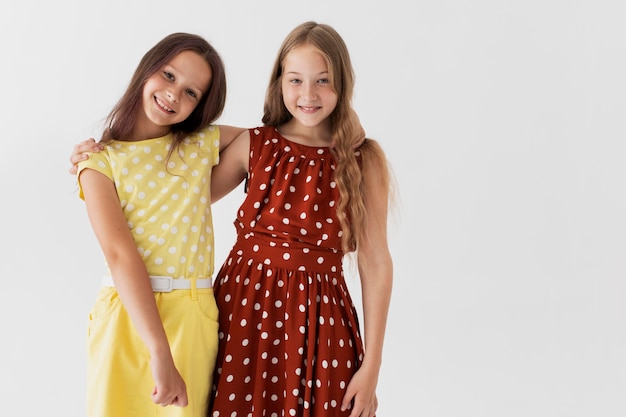 Chicas sonrientes de tiro medio posando juntos