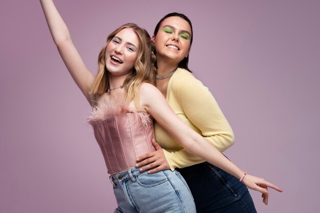 Chicas sonrientes de tiro medio posando juntos