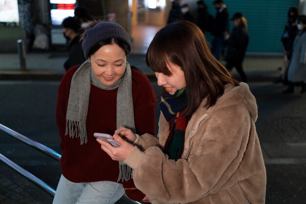 Chicas sonrientes de tiro medio con teléfono inteligente