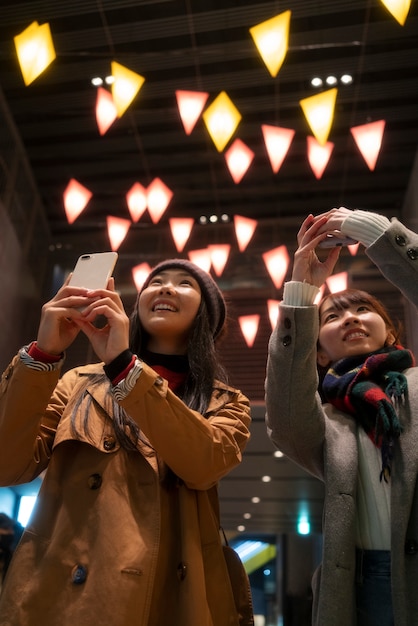 Foto gratuita chicas sonrientes de tiro medio tomando fotos