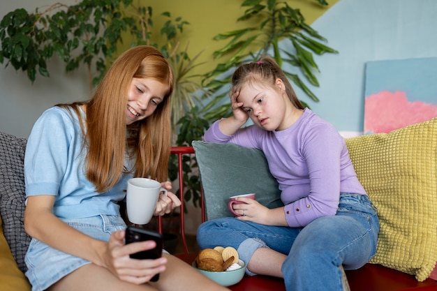 Foto gratuita chicas sonrientes tomando selfie tiro medio