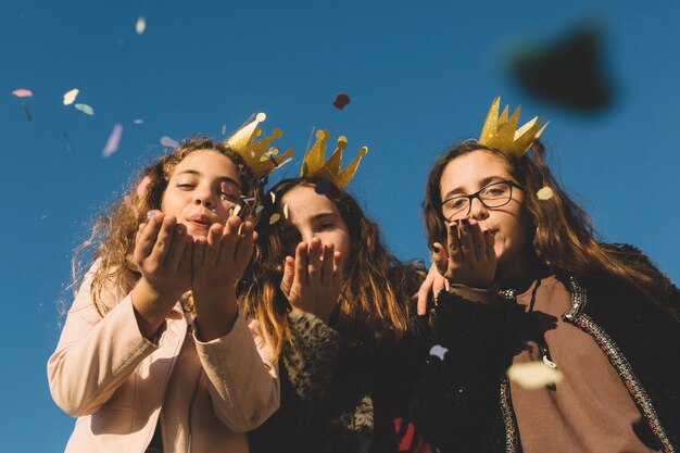 Chicas soplando confeti