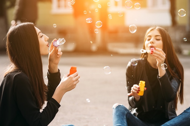 Chicas soplando pompas de jabón