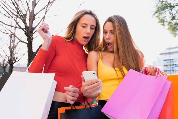 Chicas sorprendidas mirando el teléfono