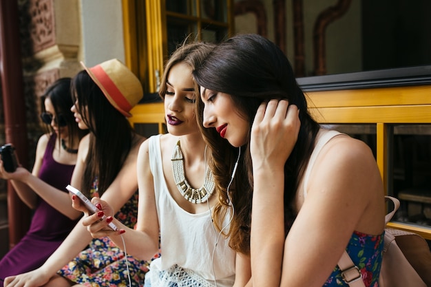 Chicas en una terraza mirando sus móviles