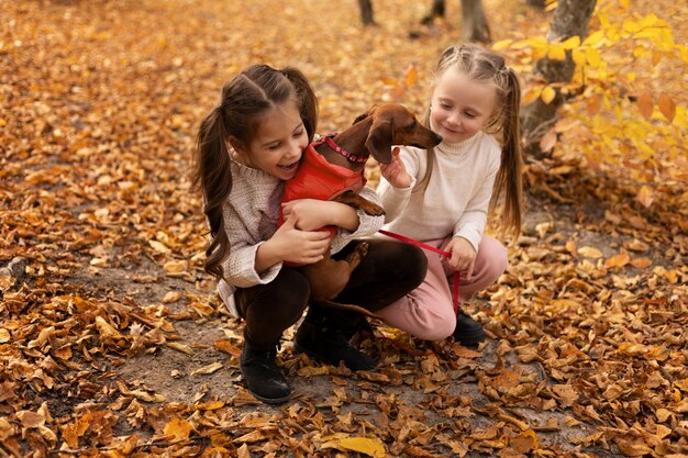 Chicas de tiro completo jugando con perro