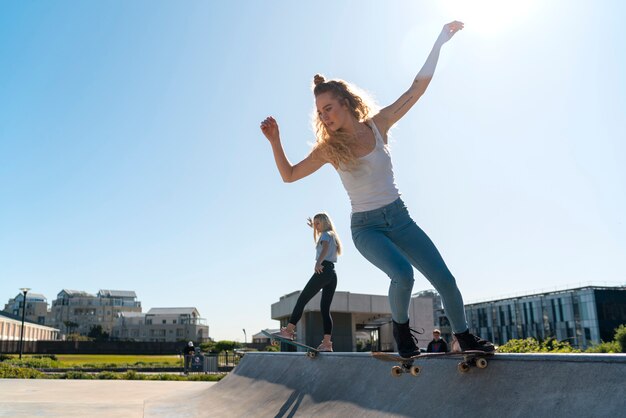 Chicas de tiro completo con patinetas.