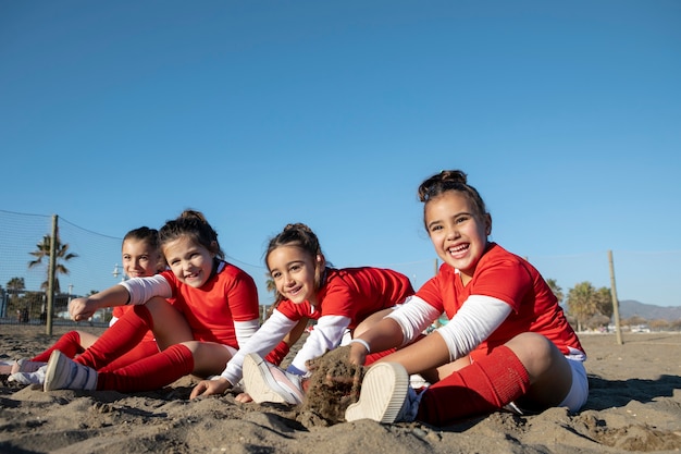 Chicas de tiro completo sentadas en la playa