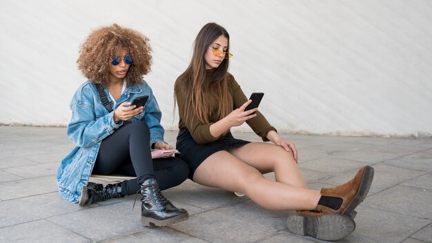 Chicas de tiro completo sentados juntos