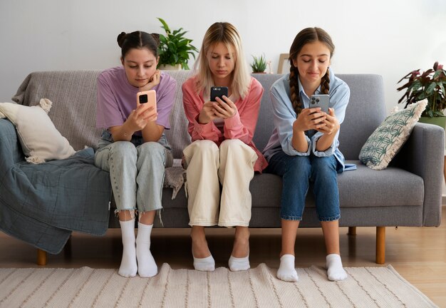 Chicas de tiro completo con teléfonos inteligentes