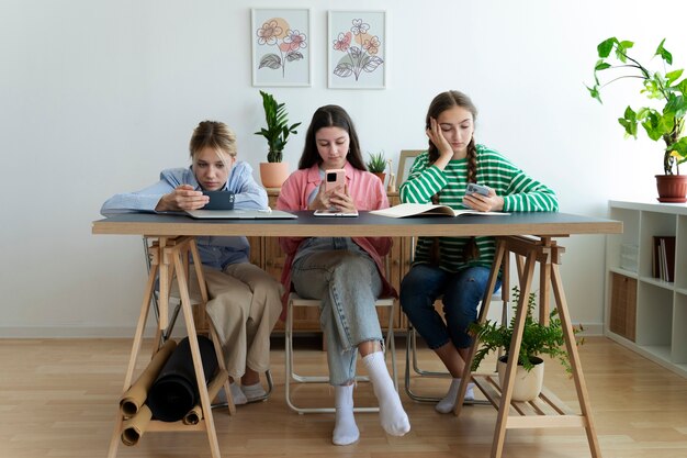 Chicas de tiro completo con teléfonos inteligentes.