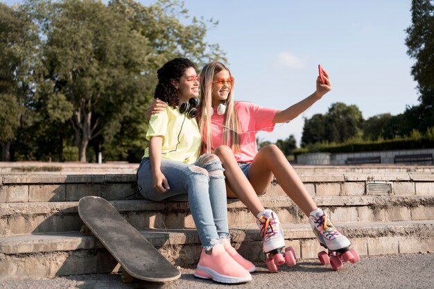 Chicas de tiro completo tomando selfies al aire libre