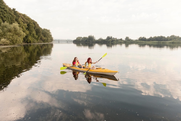 Foto gratuita chicas de tiro largo remando en kayak