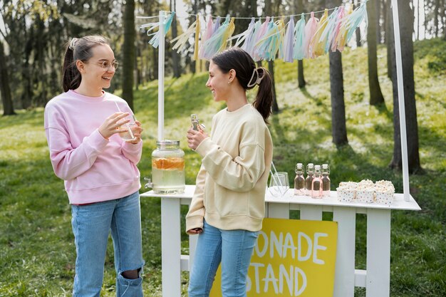 Chicas de tiro medio bebiendo limonada.