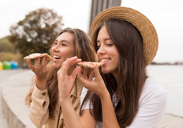 Chicas de tiro medio comiendo pizza