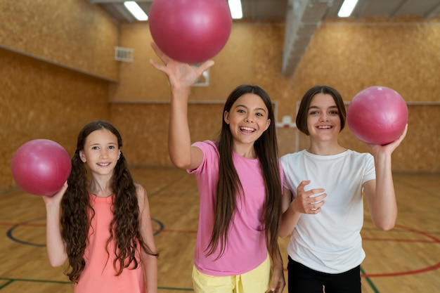 Chicas de tiro medio lanzando pelotas