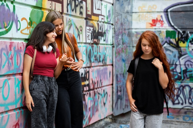 Chicas de tiro medio que intimidan a una adolescente