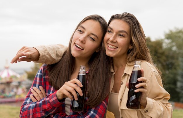 Chicas de tiro medio con refrescos