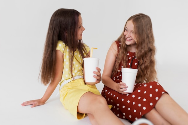 Chicas de tiro medio sosteniendo bebidas