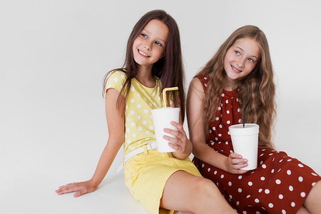 Chicas de tiro medio sosteniendo tazas