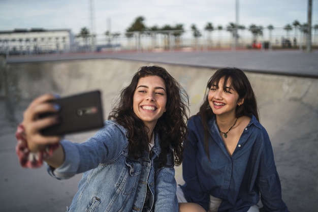 Chicas tomando una foto de sí mismas en un parque de patinaje