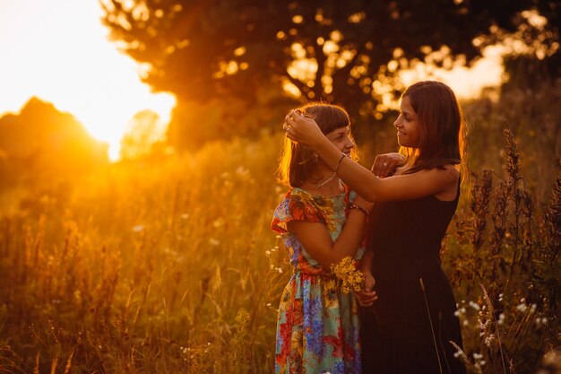 Chicas tranquilas se paran en el campo de la tarde