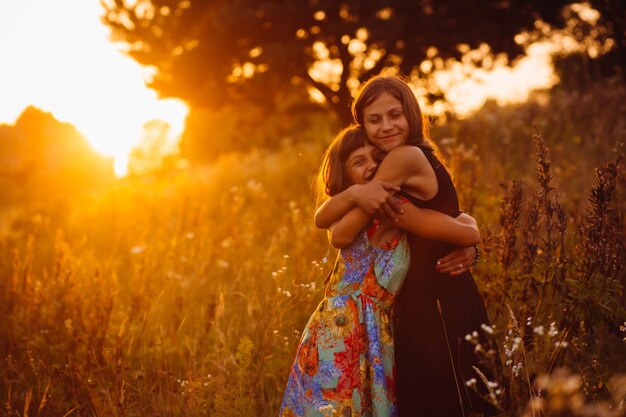 Chicas tranquilas se paran en el campo de la tarde