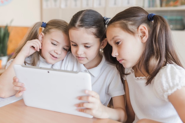 Chicas usando tableta en la escuela