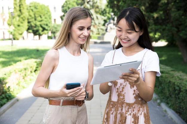 Foto gratuita chicas de vista frontal mirando tablet