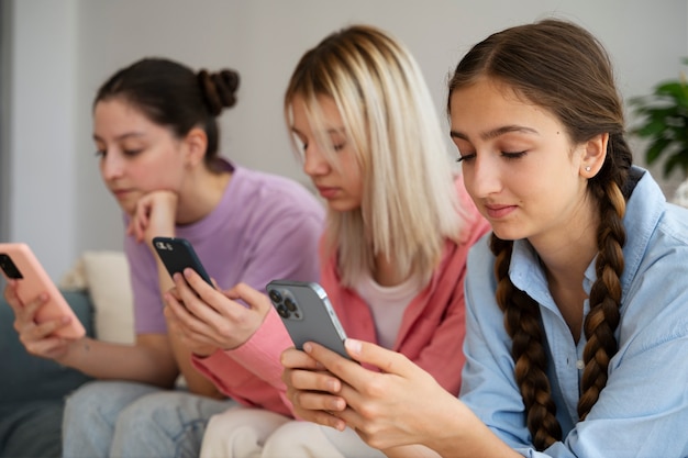 Foto gratuita chicas de vista lateral con teléfonos inteligentes