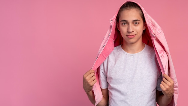 Chico adolescente elegante en rosa posando con espacio de copia