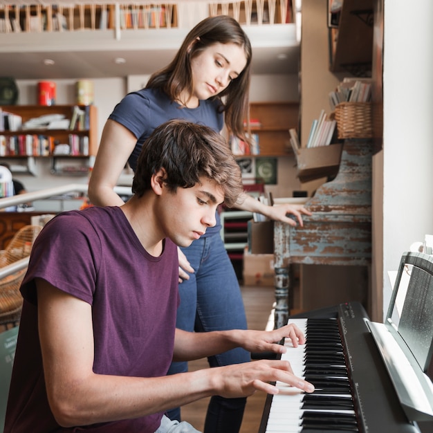 Foto gratuita chico adolescente tocando el piano para novia