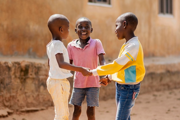 Foto gratuita chico africano sonriente de tiro medio jugando juntos